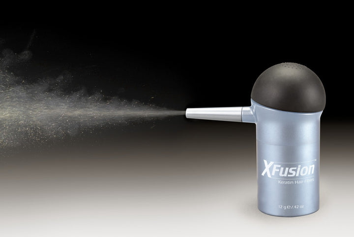 XFusion spray gun with spray in action on a dark background