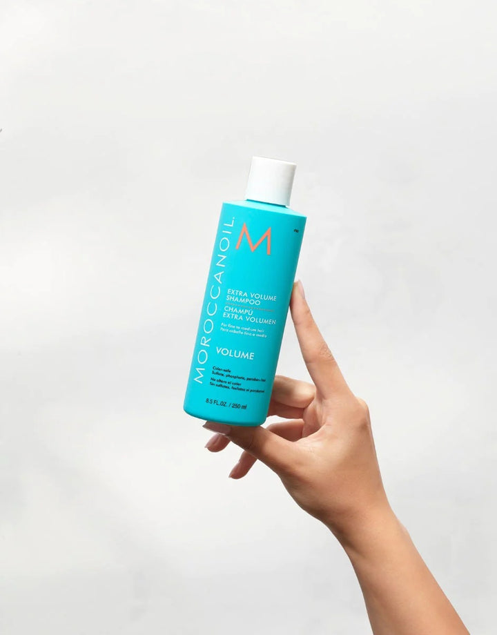 Moroccanoil Extra Volume Shampoo image of model holding bottle