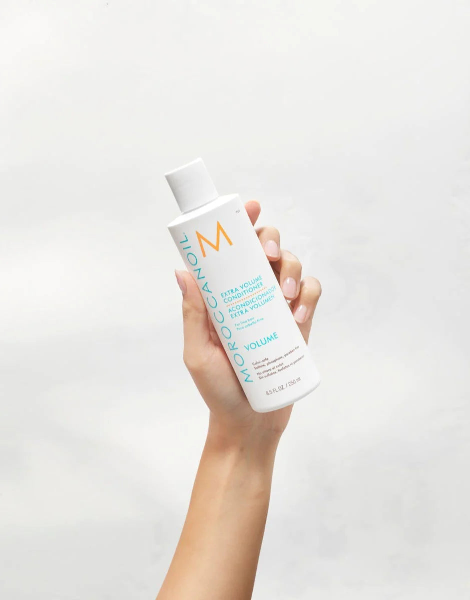 Moroccanoil Hydrating Conditioner image of model holding 8.5 oz bottle