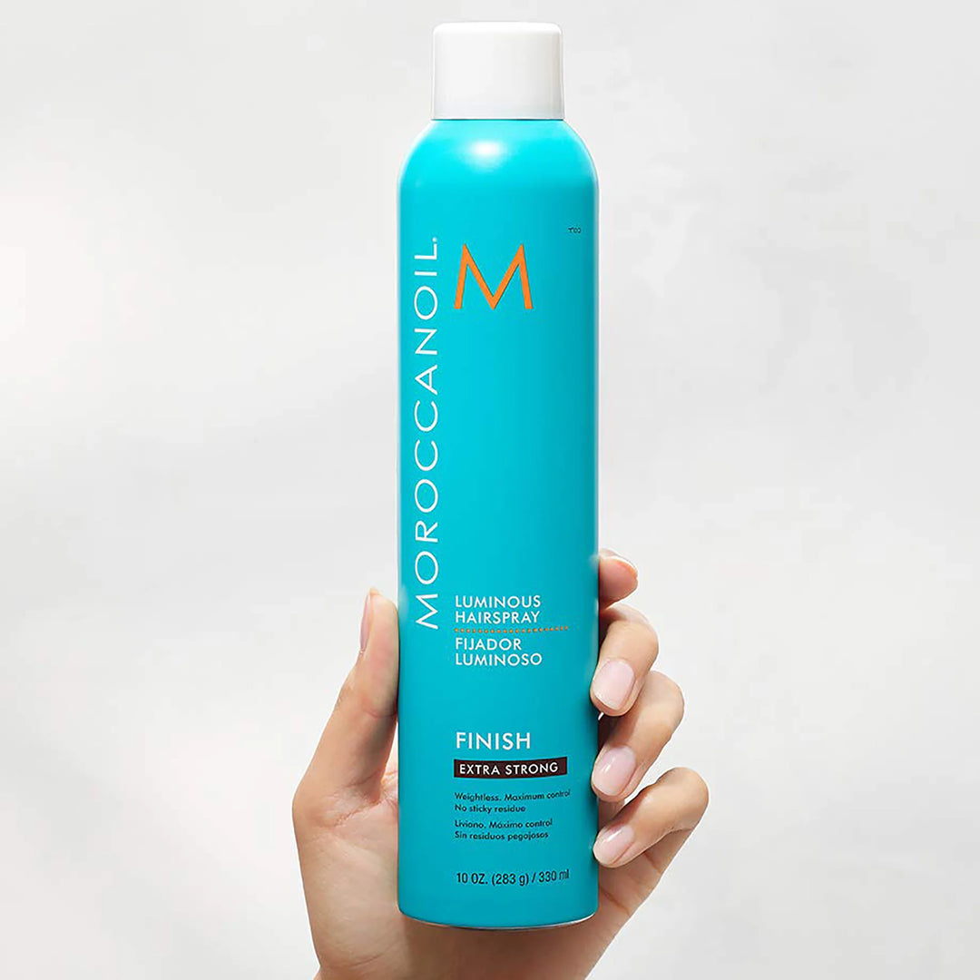 Moroccanoil Luminous Hairspray Extra Strong image of model holding bottle