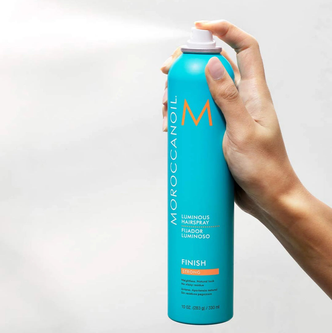 Moroccanoil Luminous Hairspray Strong image of model spraying 10 oz bottle