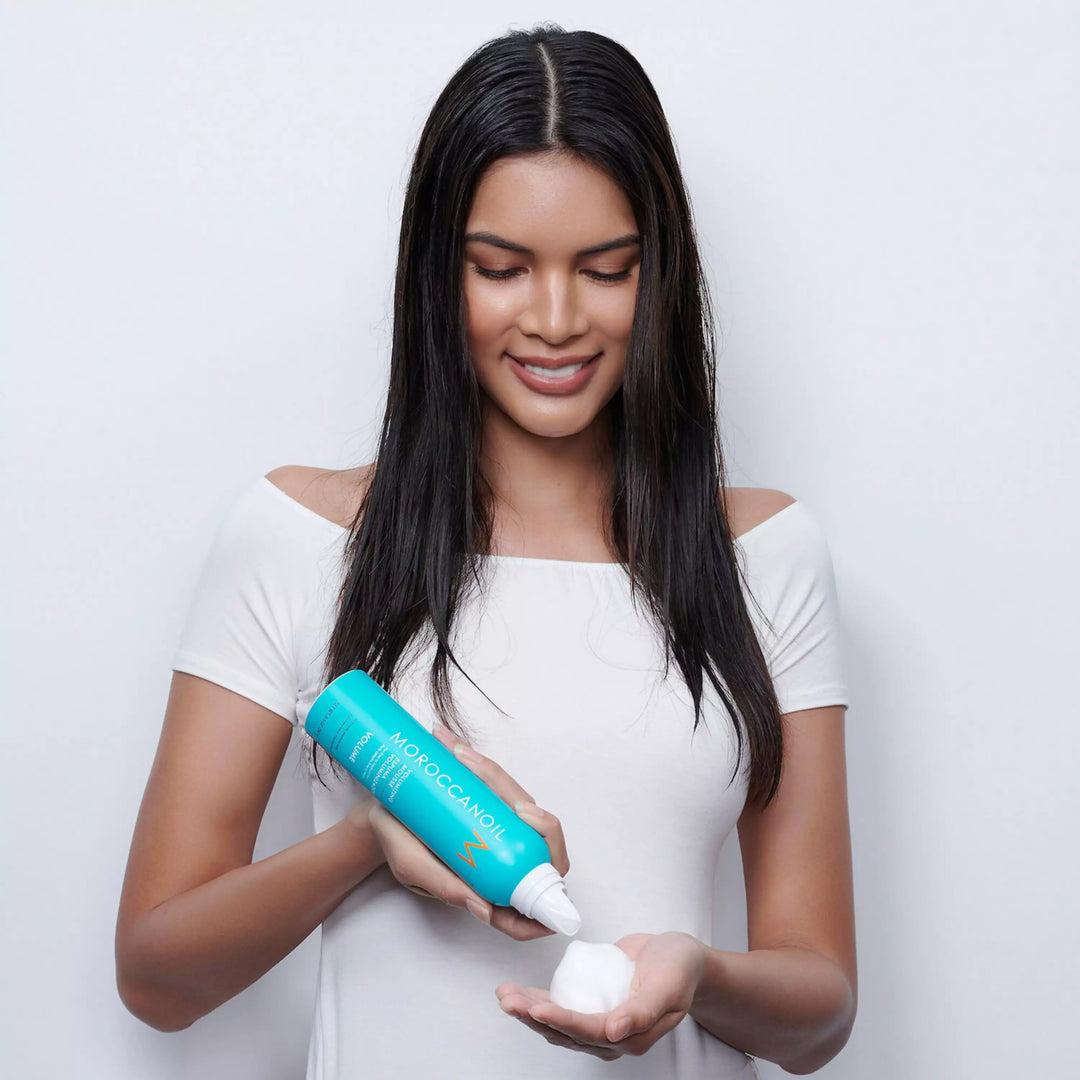 Moroccanoil Volumizing Mousse image of model dispensing mouse into hand
